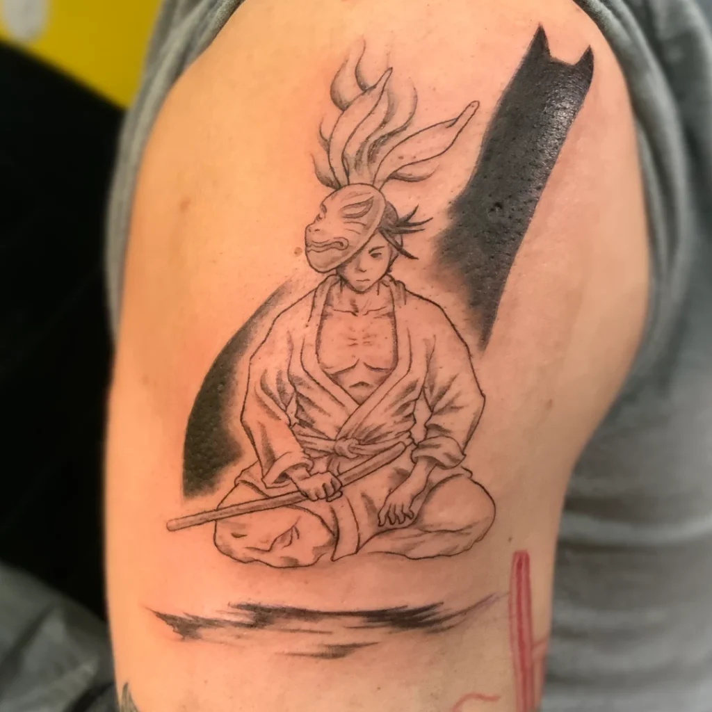 A shoulder tattoo of a samurai wearing a rabbit mask half-cocked to the side. The samurai is overlapping an elongated dog's shadow. Rendered in black and grey.