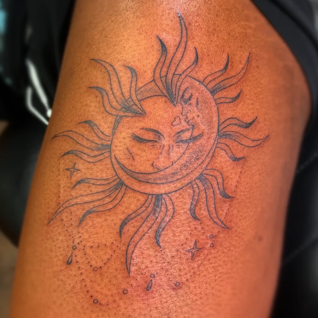 a thigh tattoo of a sun and moon embracing.