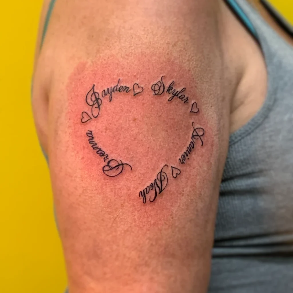 A tattoo of a series of names forming the outline of a heart on the upper arm.