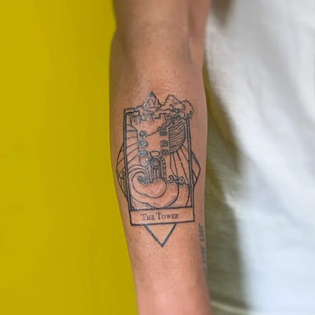 A tattoo of the tower tarot card on the upper forearm.