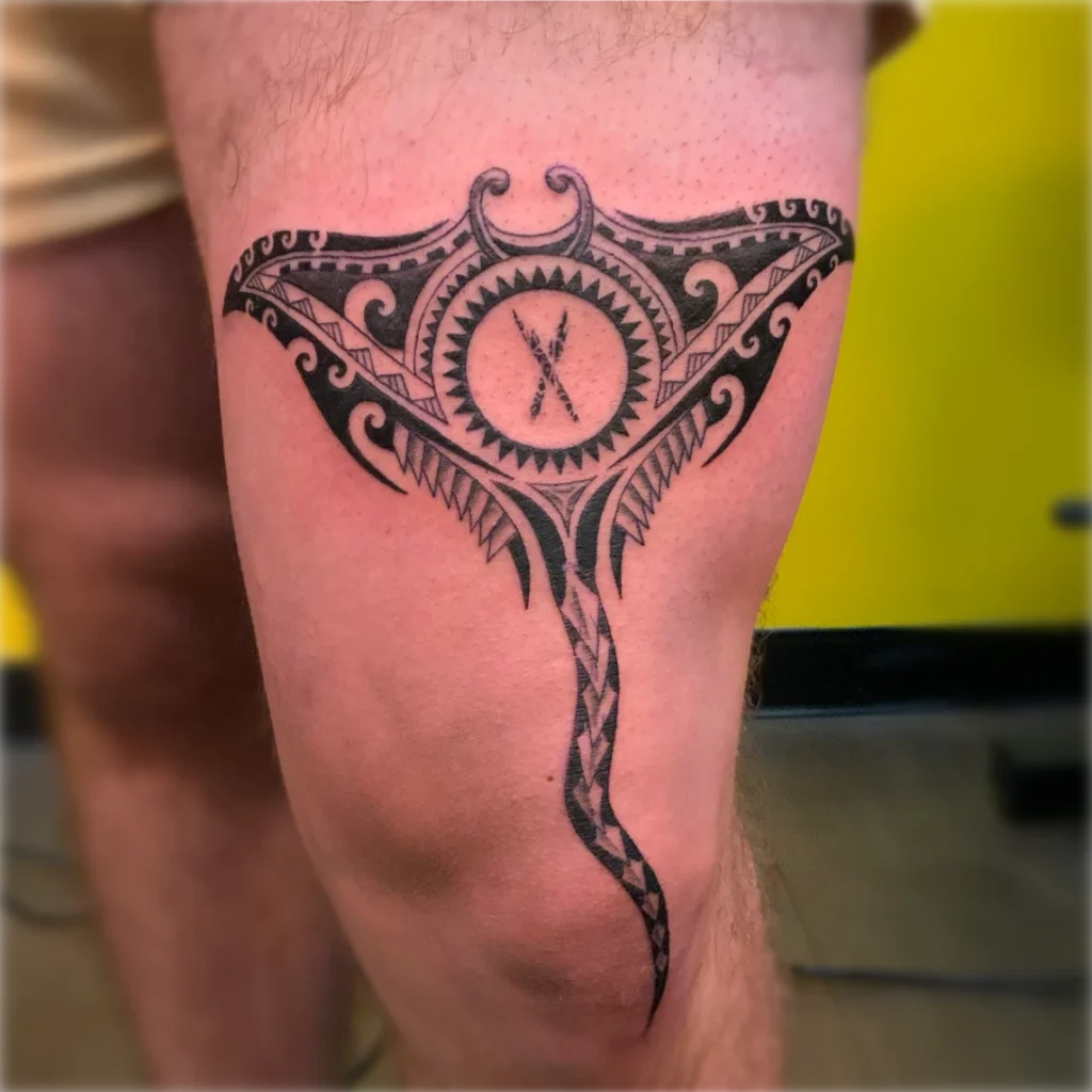 A Polynesian Tattoo of a manta ray on the thigh, with tail extending past knee.